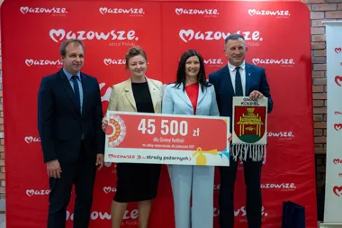Cztery osoby stoją przed czerwoną ścianką z logotypem Mazowsze i trzymają czek na 45 500 zł dla Gminy Kotbiel na zakup wyposażenia dla jednostek OSP oraz gminow